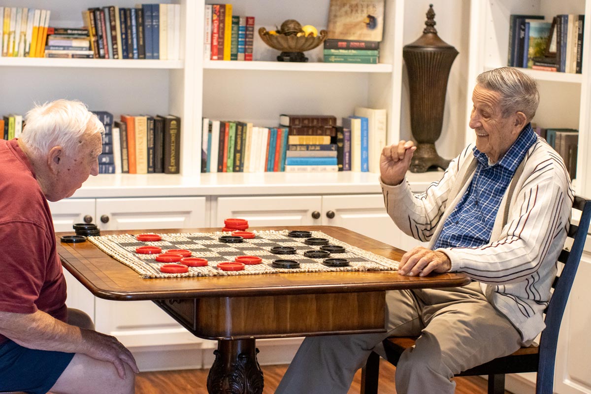Two senior residents playing checkers at Orchard Ridge Residences
