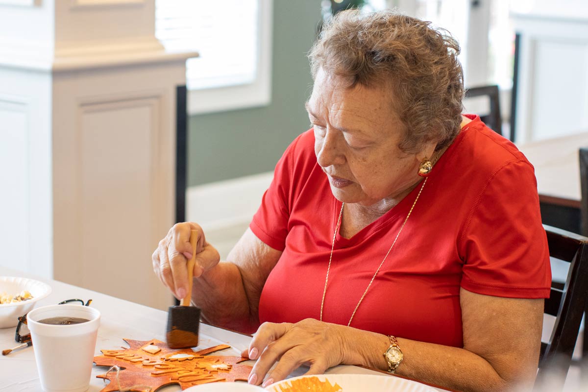 Senior resident lady at Orchard Ridge Residences making crafts for autumn