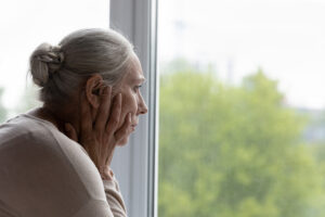 Old woman glaring at the window looking outside